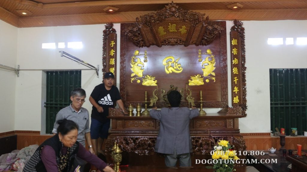 gia chủ đang bày biện trên bộ sập thờ